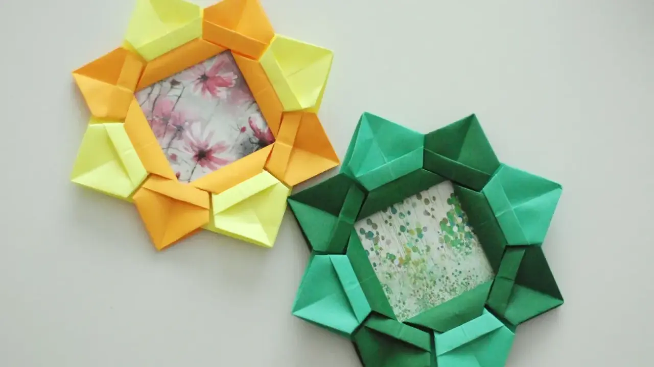 Dwa ozdobne ramki na zdjęcia diy w kształcie gwiazdy, wykonane z kolorowego papieru origami. Jedna żółto-pomarańczowa, druga zielona.