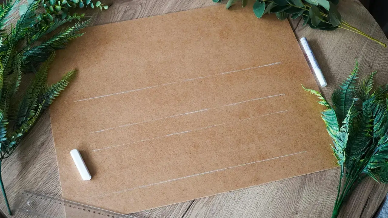 Przygotowania do ślubu: karton, kreda i zielone liście do stworzenia własnych dekoracje weselne diy.