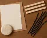 Materiały do stworzenia ramki z papieru: papier, masa plastyczna, patyczki i listewki.