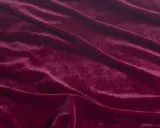 Głęboki, burgundowy welur układa się w miękkie fale, przypominając aksamitny dywan.
