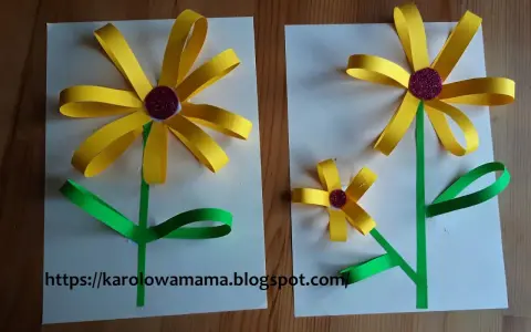 Proste kwiaty z papieru dla dzieci. Dwa żółte słoneczniki z zielonymi łodygami i liśćmi, wykonane z papieru.
