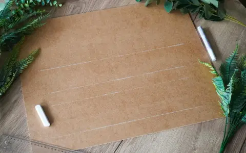 Przygotowania do ślubu: karton, kreda i zielone liście do stworzenia własnych dekoracje weselne diy.