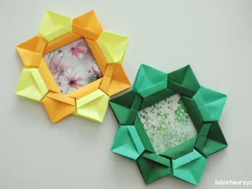 Dwa ozdobne ramki na zdjęcia diy w kształcie gwiazdy, wykonane z kolorowego papieru origami. Jedna żółto-pomarańczowa, druga zielona.
