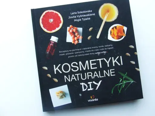 Okładka książki "Kosmetyki Naturalne DIY" z pomarańczą, owocami rokitnika, migdałami i ziołami.
