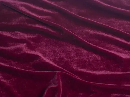 Głęboki, burgundowy welur układa się w miękkie fale, przypominając aksamitny dywan.