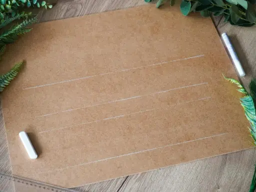 Przygotowania do ślubu: karton, kreda i zielone liście do stworzenia własnych dekoracje weselne diy.