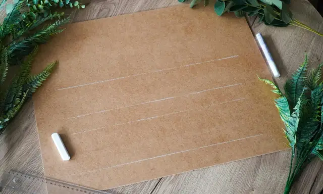 Przygotowania do ślubu: karton, kreda i zielone liście do stworzenia własnych dekoracje weselne diy.